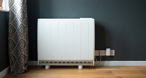 white electric heater against a dark wall with wooden floor and curtain enhances warmth in five easy steps