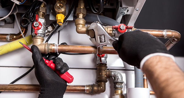 person using a wrench to repair plumbing pipes number 11 plumbing maintenance assistance