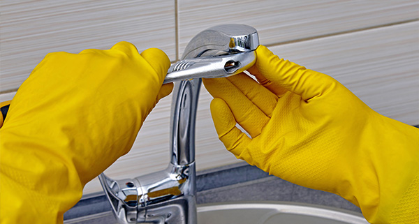 man repairing toilet tank with tools focusing on plumbing maintenance and repairs for bathrooms