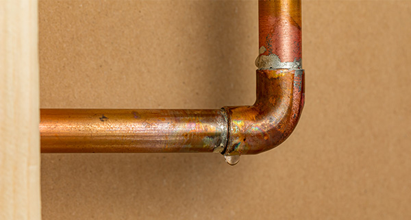 copper pipe joint with water dripping showing leak repair options for plumbing four ways to fix leaks
